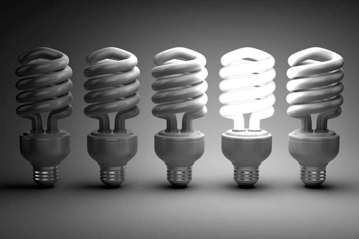 Five lightbulbs with only the fourth one illuminated, representing innovation and leadership at African Energy Week 2023.